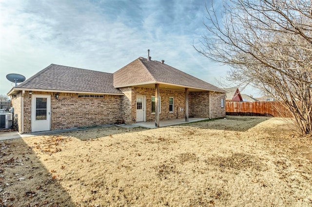 back of property featuring a lawn and central air condition unit