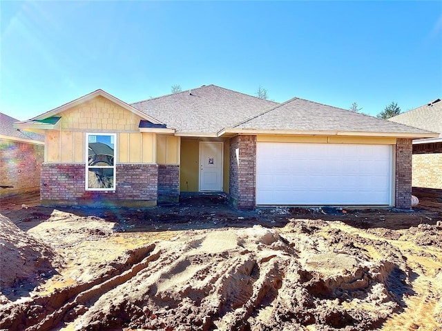 single story home featuring roof with shingles and an attached garage