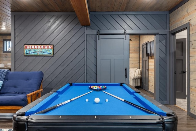 rec room with a barn door, wood walls, beamed ceiling, hardwood / wood-style flooring, and pool table