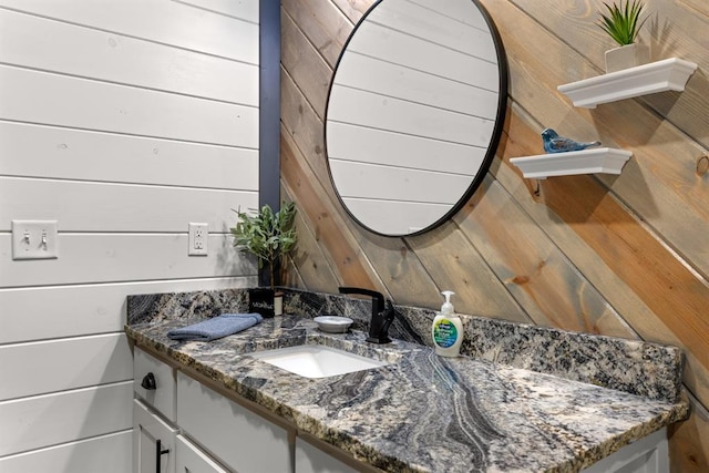 bathroom featuring vanity and wooden walls