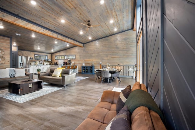 living room with lofted ceiling, ceiling fan, wood walls, and wooden ceiling