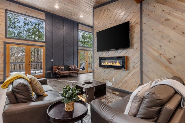 living room featuring wooden ceiling, french doors, and wooden walls