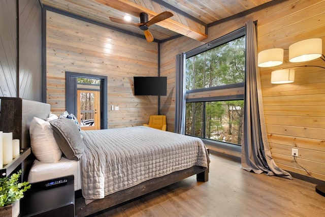 bedroom with ceiling fan, wooden ceiling, multiple windows, and beamed ceiling