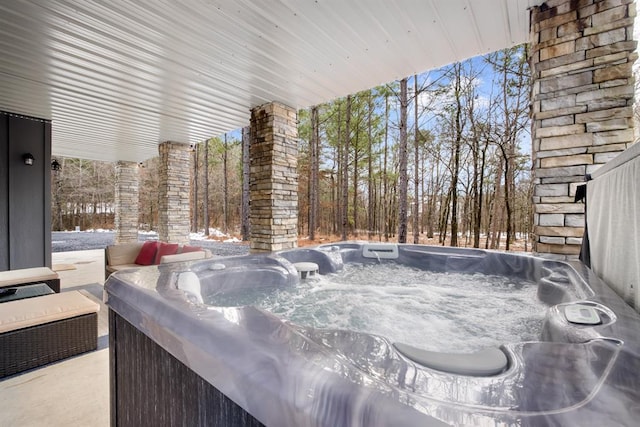 snow covered patio featuring a hot tub