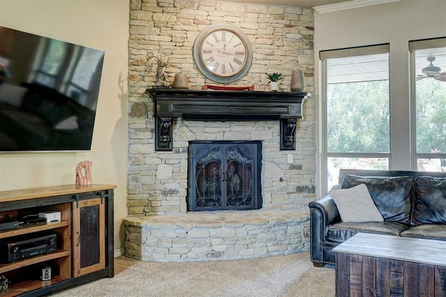 carpeted living area with a stone fireplace and ornamental molding