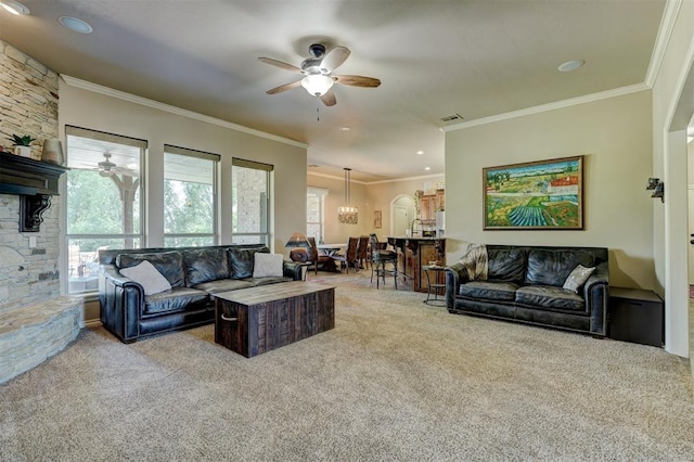 carpeted living area featuring visible vents, crown molding, and a ceiling fan