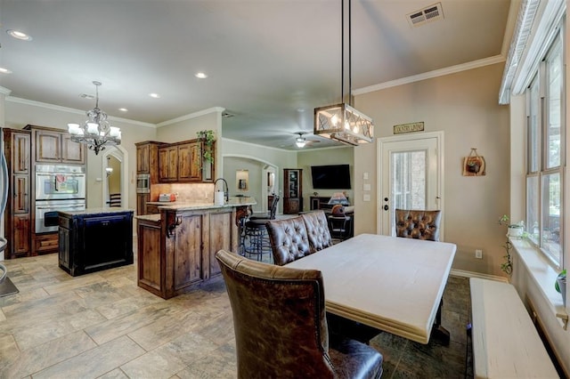 dining room with visible vents, baseboards, ornamental molding, recessed lighting, and arched walkways