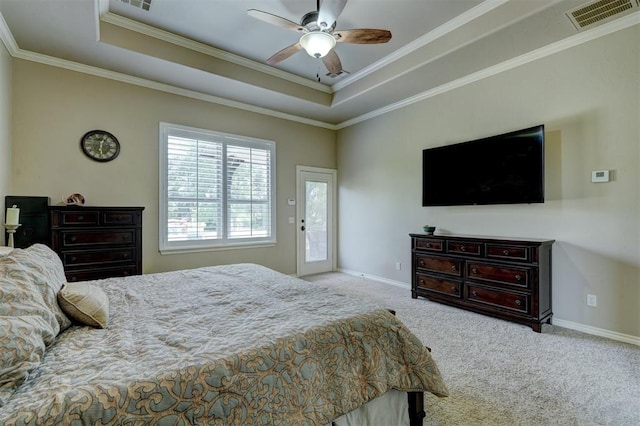 carpeted bedroom with a tray ceiling, baseboards, and visible vents