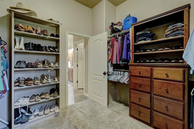 spacious closet featuring light tile patterned floors and light carpet