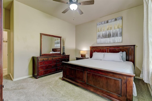 bedroom featuring light colored carpet, baseboards, and ceiling fan