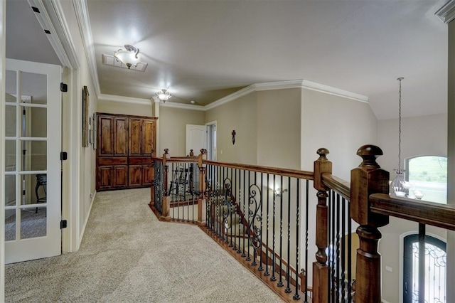 corridor with light carpet, an upstairs landing, and crown molding