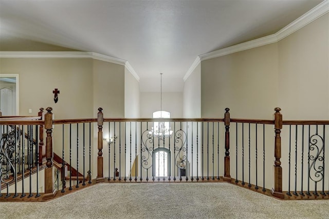 hall with a chandelier, carpet flooring, an upstairs landing, and crown molding