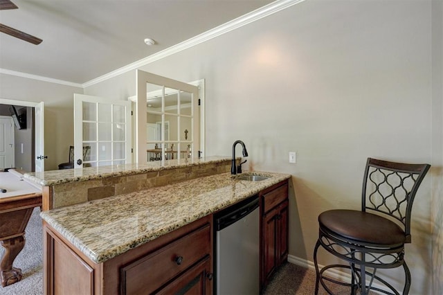 kitchen with dishwasher, ornamental molding, light stone countertops, and a sink