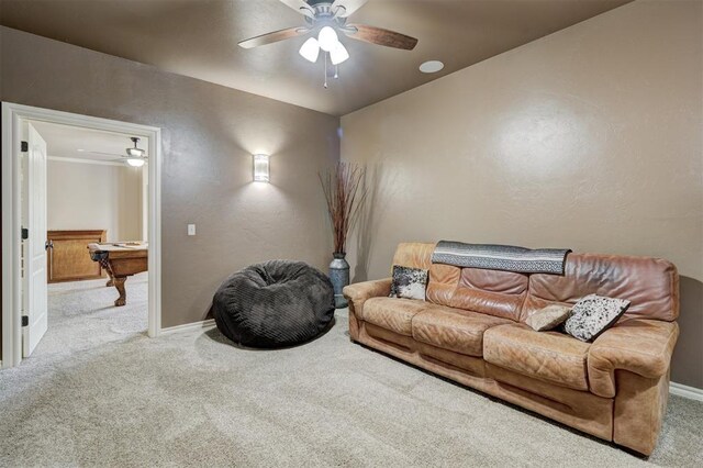 living area with baseboards, carpet, ceiling fan, and a textured wall