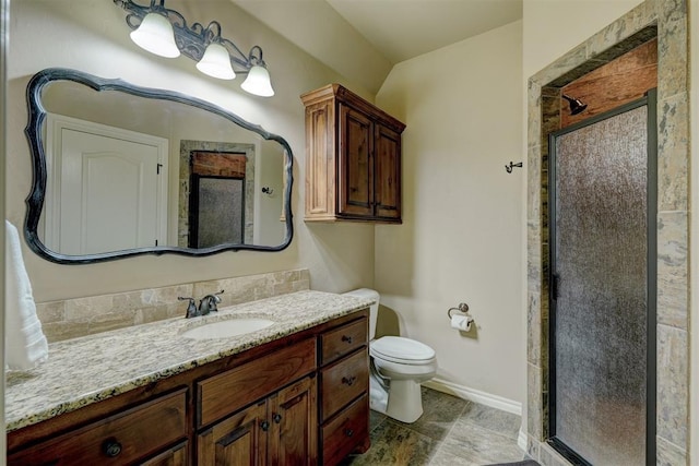 bathroom featuring vanity, toilet, baseboards, and a stall shower