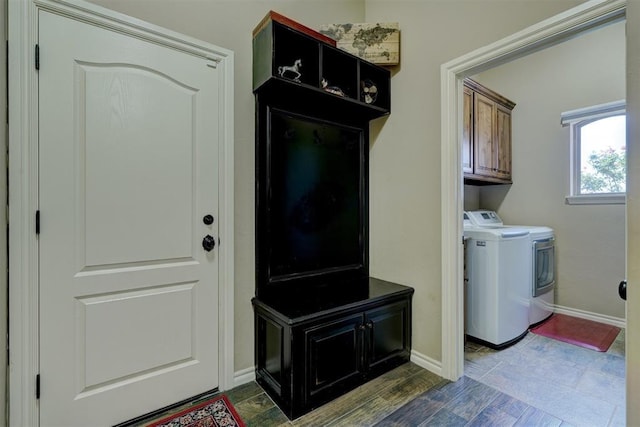 laundry room featuring cabinet space, baseboards, dark wood-style flooring, and washing machine and clothes dryer