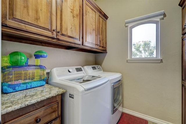 laundry room with cabinet space, baseboards, and washing machine and clothes dryer