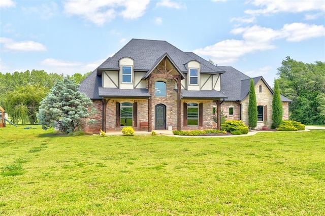 view of front of home featuring brick siding, stucco siding, a shingled roof, and a front lawn