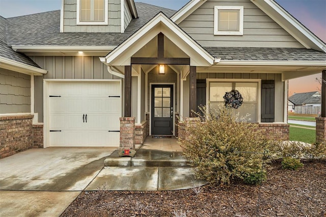 exterior entry at dusk featuring a garage