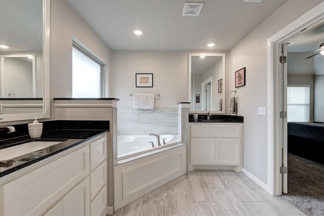 bathroom featuring vanity, a bath, and ceiling fan