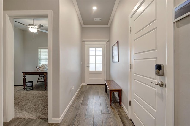 doorway with hardwood / wood-style flooring, ceiling fan, and crown molding