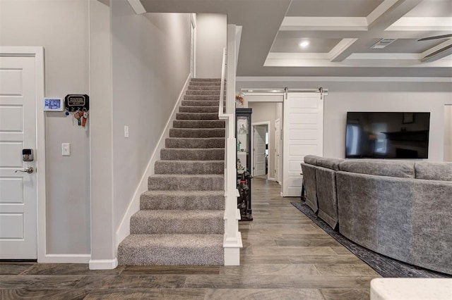 stairway featuring coffered ceiling, hardwood / wood-style flooring, beam ceiling, and a barn door