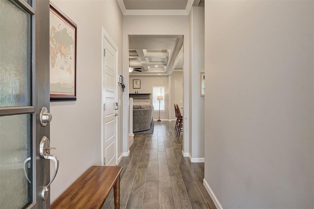 hall with coffered ceiling, beam ceiling, ornamental molding, and dark hardwood / wood-style floors