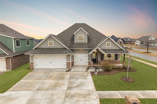 craftsman house featuring a garage, a yard, and covered porch