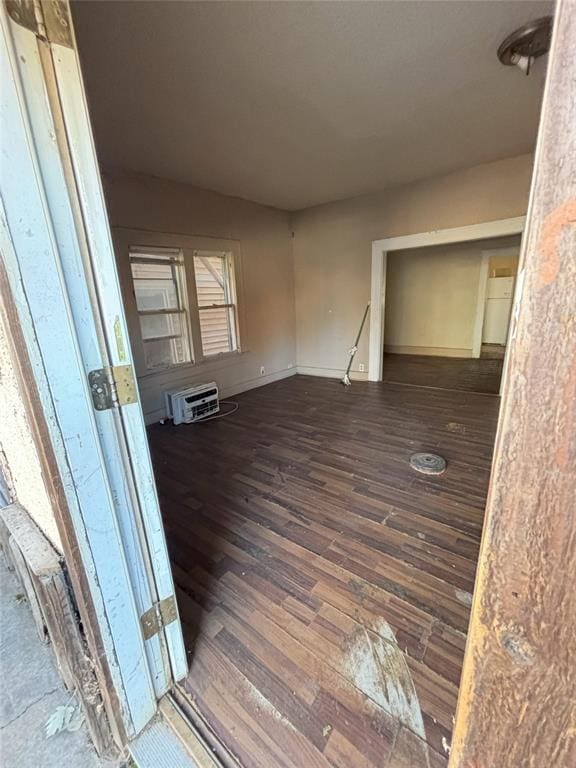 interior space featuring dark wood-type flooring and a wall mounted air conditioner