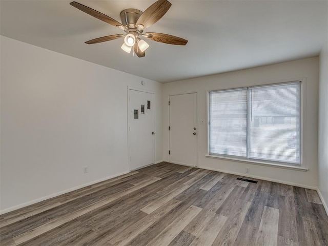 empty room with ceiling fan and light wood-type flooring