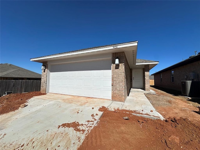 view of front facade with driveway, brick siding, cooling unit, and fence