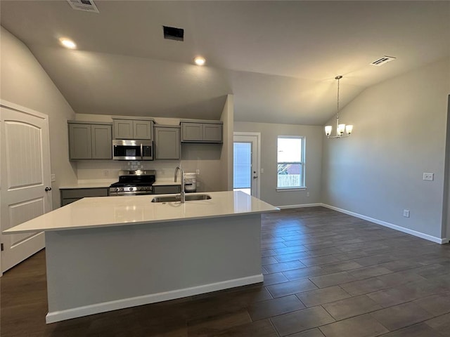 kitchen with gray cabinetry, stainless steel appliances, a sink, visible vents, and vaulted ceiling