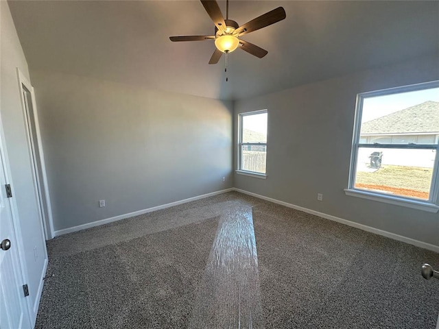 carpeted spare room with a ceiling fan and baseboards