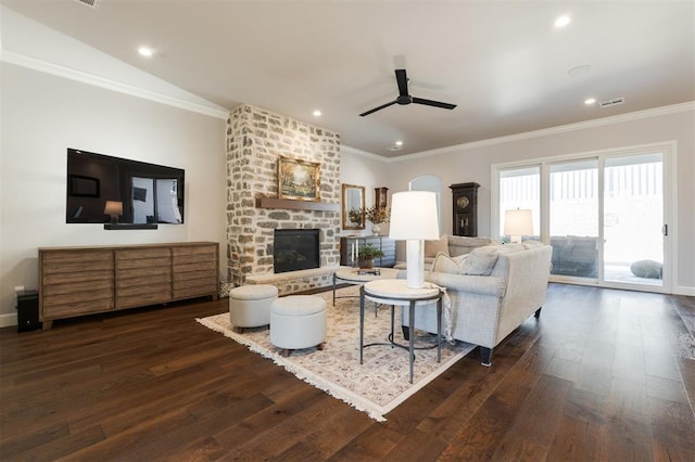 living room with ceiling fan, crown molding, dark wood-type flooring, and a fireplace