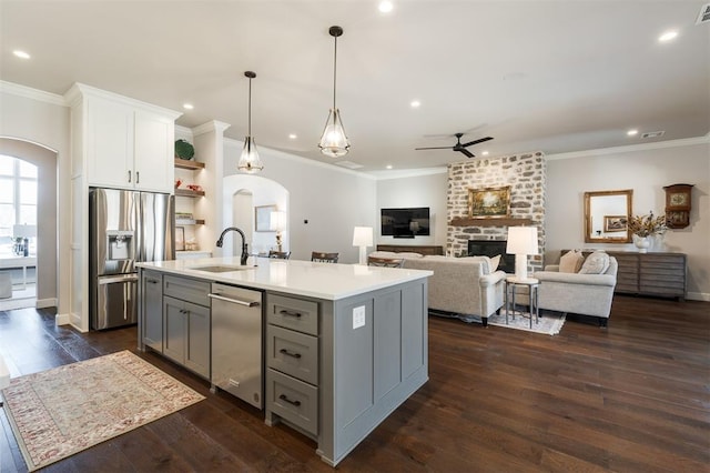 kitchen with pendant lighting, white cabinets, gray cabinetry, a center island with sink, and stainless steel appliances