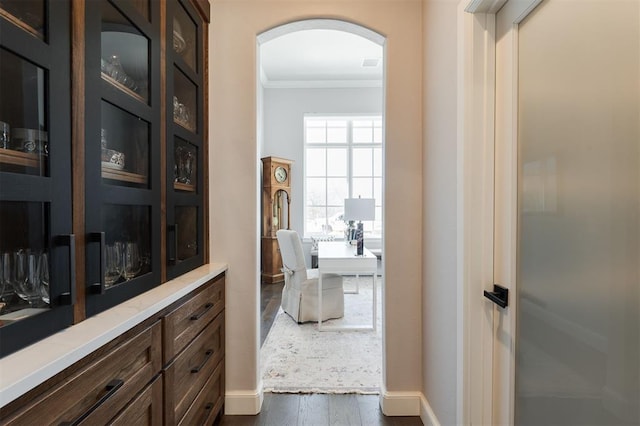 hallway with dark hardwood / wood-style flooring and crown molding