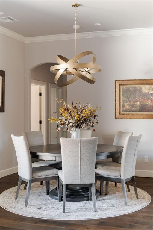 dining room featuring ornamental molding and dark hardwood / wood-style floors