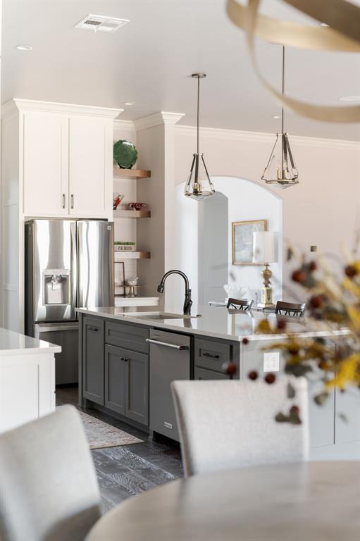 kitchen featuring hanging light fixtures, appliances with stainless steel finishes, sink, white cabinets, and gray cabinets