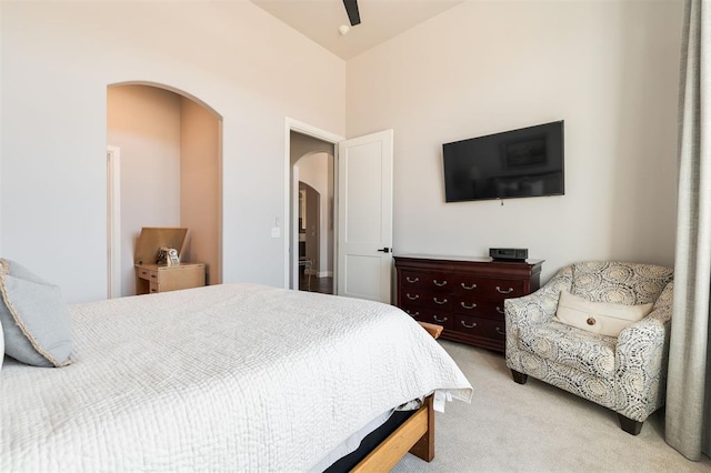 bedroom featuring ceiling fan, vaulted ceiling, and light carpet