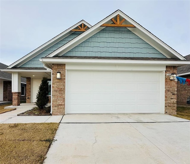 view of front of house featuring brick siding, a garage, and driveway