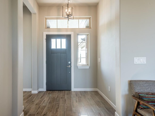 foyer entrance featuring hardwood / wood-style flooring and an inviting chandelier