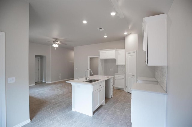 3120 Warwick Way, Moore, OK 73160 - kitchen with a ceiling fan, backsplash, a kitchen island with sink, white cabinetry, and recessed lighting
