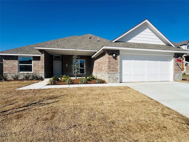 view of front facade featuring brick siding, a shingled roof, concrete driveway, a front yard, and an attached garage