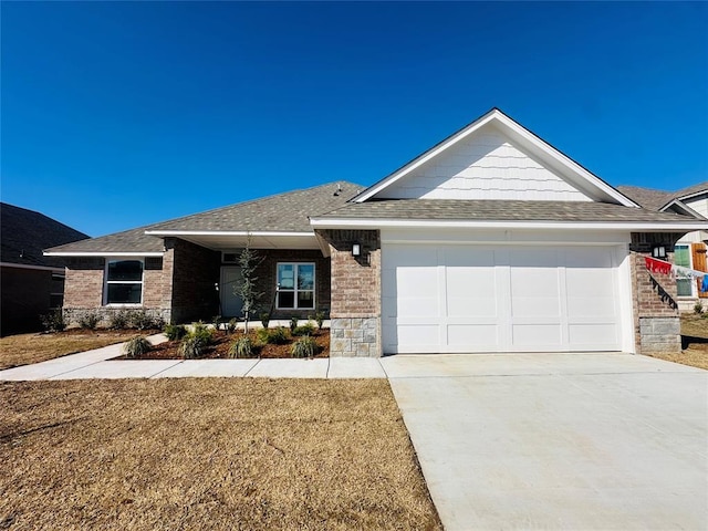 view of front of property featuring a garage, brick siding, roof with shingles, and concrete driveway