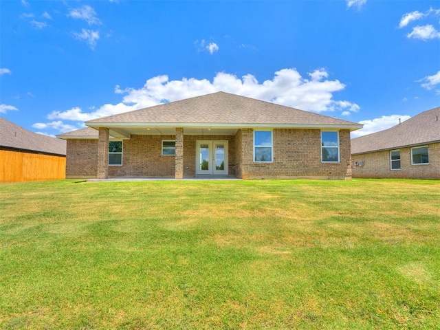 rear view of property with a lawn and french doors