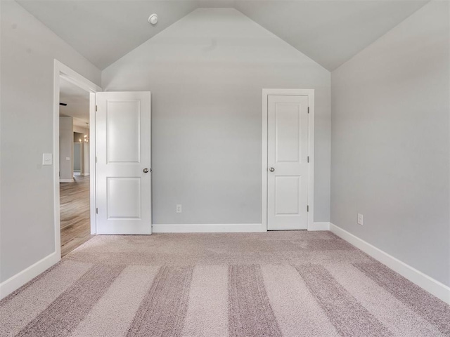 interior space featuring carpet floors and vaulted ceiling