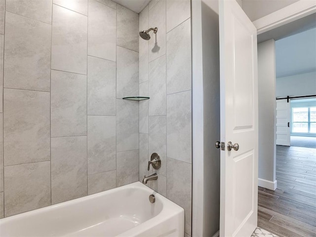 bathroom featuring tiled shower / bath combo and hardwood / wood-style flooring