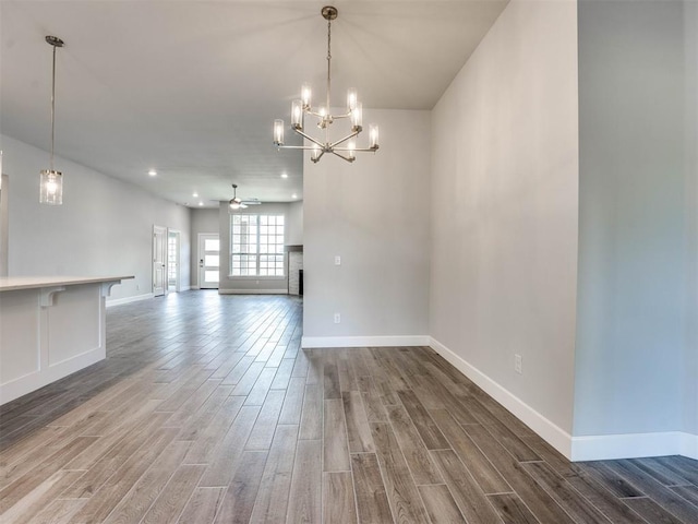 interior space with ceiling fan with notable chandelier