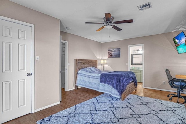 bedroom featuring ceiling fan, dark wood-type flooring, and ensuite bath