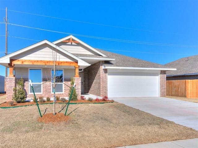 view of front facade featuring a garage, a front yard, and covered porch